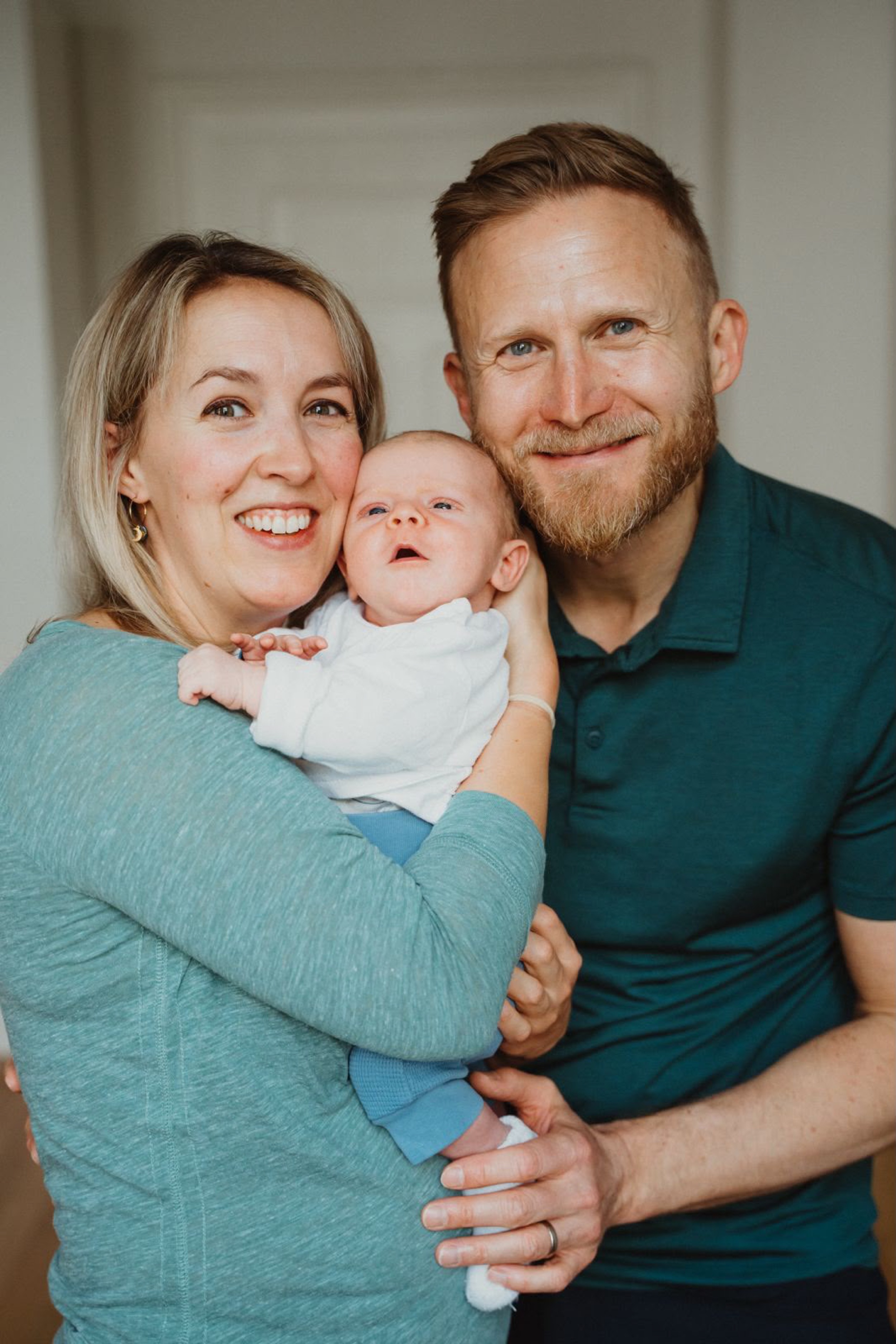 Happy parents smiling while holding their baby, finally sleeping well again